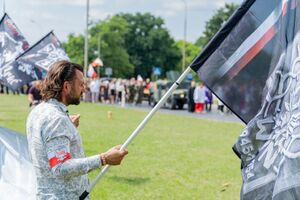 Uczestnik uroczystości pogrzebowych machający flagą ze znakiem Zrzeszenia Wolność i Niezawisłość. Fot. Dawid Florczak/IPN Lublin